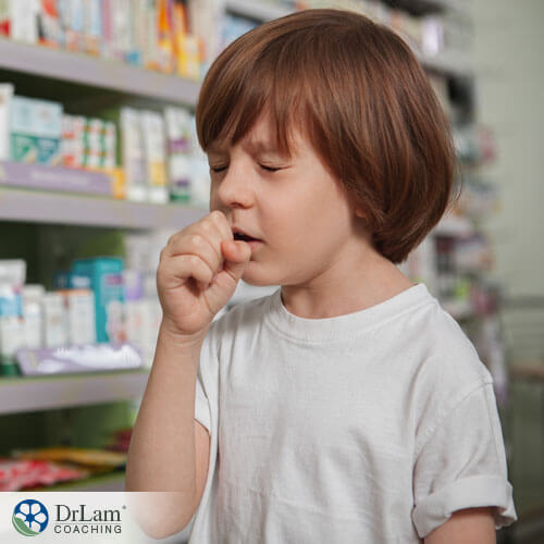An image of a sick little boy coughing into his hand