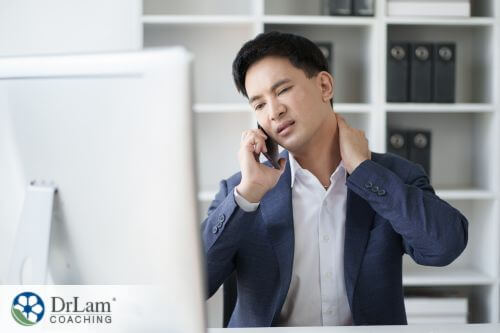 An image of a stressed-looking man staring in a computer while on phone