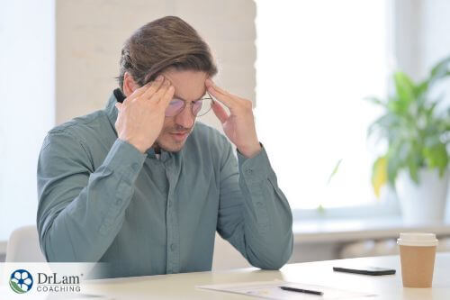 An image of a man holding his head in pain