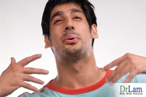 A man looking uncomfortable and fanning himself with his hands seeming feeling hot and perhaps suffering from Adrenal Fatigue symptoms