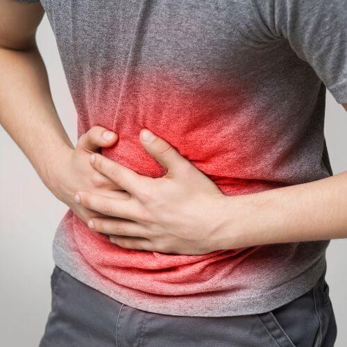 An image of a person holding their stomach, asking: Does Constipation Cause Weight Gain