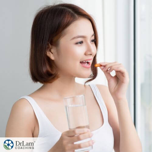 An image of a woman taking a supplement