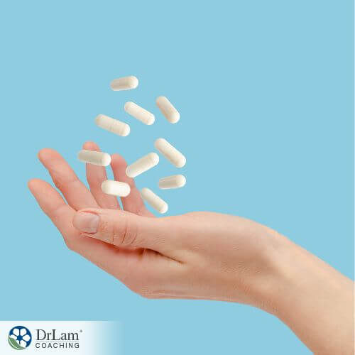 An image of a hand with white capsules