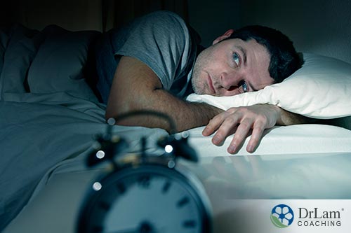 An image of a man laying in bed unable to sleep
