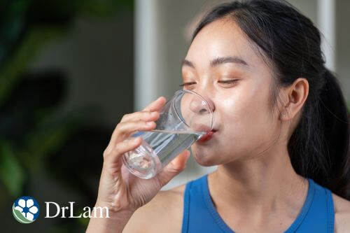 A photo of a woman drinking a glass water