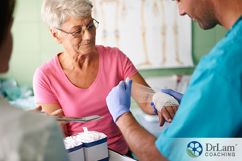 An image of an older woman having her wound dressed by a nurse