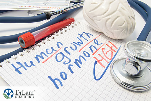 An image of a test tube full of red liquid, a stethoscope, and a notebook of graph paper with human growth hormone HGH written on the page